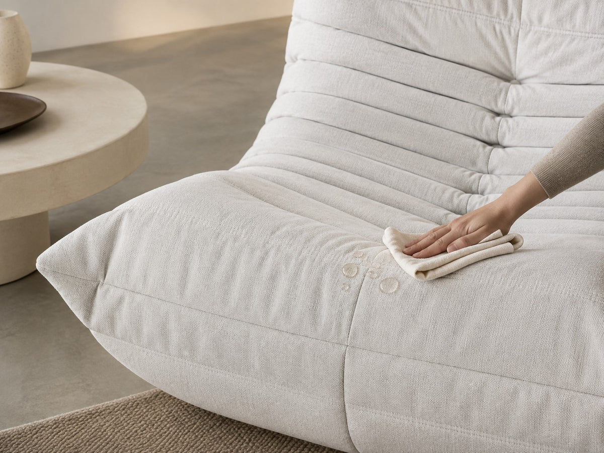 Une main tamponne une goutte avec un chiffon humide sur un Goto blanc
